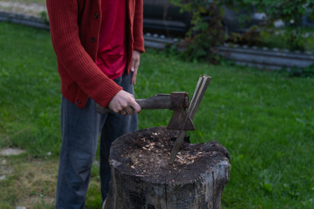 A man is chopping wood for a bonfir A man is chopping small firewood. Eveningの写真素材