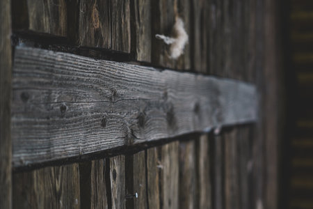 A dark wooden wall. A wooden board across other boards. Wooden backgroundの写真素材