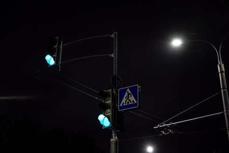 Green traffic light for cars. Traffic lights at night in the cityの写真素材