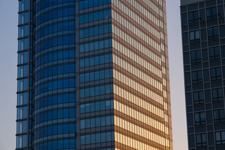 A skyscraper at sunset in the evening. Glass skyscraper close-up. Skyscraper close-up at sunset....