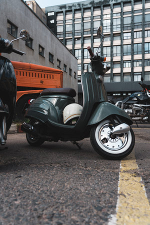 A scooter parked in the parking lot. Vintage moped on display