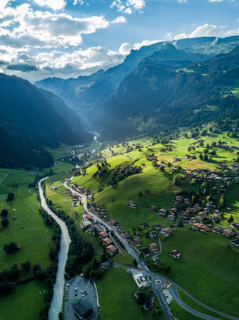 Sun shines over Swiss village Grindelwald after heavy storm in summer time near Swiss Alpsの写真素材
