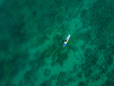 Aerial drone shot view of surfers in pacific ocean near Waikiki beach, Honolulu, Hawaii