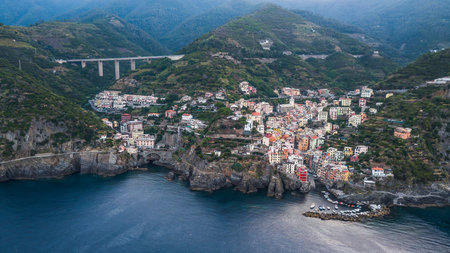 Aerial drone shot view of Riomaggiore village early morning in Cinque Terre, Italy