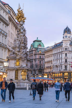 Vienna, Austria - April 28, 2019: People walking on the street passing by column of plague in old townのeditorial素材