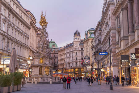 Vienna, Austria - April 28, 2019: People walking on the street passing by column of plague in old townのeditorial素材