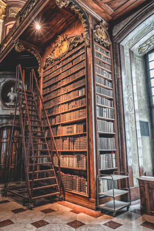 Vienna, Austria - April 28, 2019: Ladders besides antique bookshelf filled with old books inside imperial libraryのeditorial素材