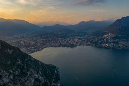 Aerial drone shot sunset view of Lugano city by lake, Monte Bre and Mont Salvatoreの写真素材