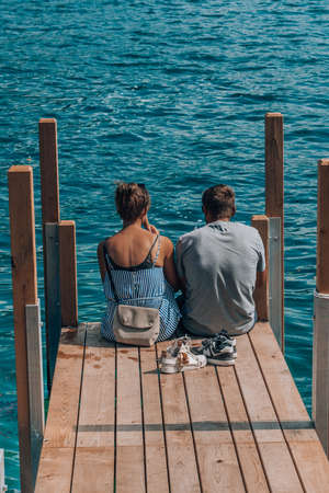 Lugano, Switzerland - Lovers eat ice cream at the dock of Lugano Lake in summer timeの写真素材