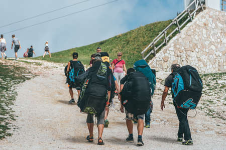 Monte Baldo, Italy - August 8, 2019: Paragliders walk on top of Monte Baldo by Lake Garda areaのeditorial素材