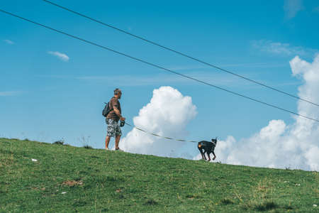 Monte Baldo, Italy - August 8, 2019: A man walk his dog on top of monte baldo in lake gardaのeditorial素材