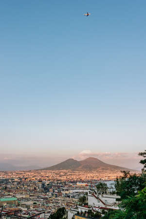 A plane fly over Mont Vesuvius volcano with Naples city in the foregroundの写真素材