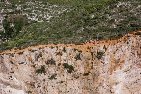 Zakynthos, Greece - August 20, 2019: Aerial drone shot of tourists on dangerours cliff to see shipwreck bay navagio beachのeditorial素材