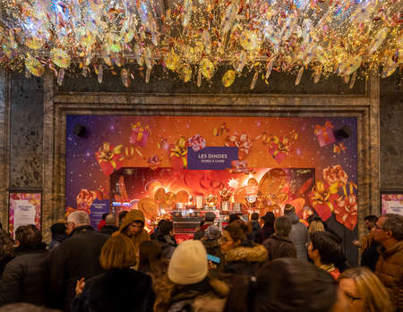 Paris, France - December 1, 2019: Parisiens admire Printemps boutique vitrine showcase display with Christmas lightingsのeditorial素材
