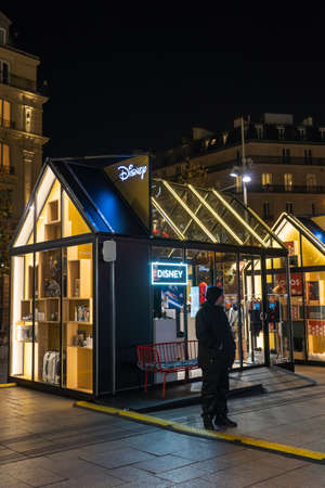 Paris, France - December 4, 2019: Security guard stands outside Christmas Pop-up store of Disny near train station Gare St Lazareのeditorial素材