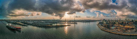 Panoramic view of port of Hamburg from Hafencity before sunset with dramatic stormy clouds with sunlight over the seaの写真素材