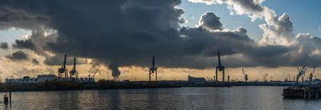 Panoramic view of Hamburg Harbor from Hansestadt with dramatic stormy clouds and sunlightの写真素材
