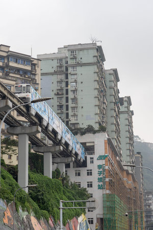 Chongqing, China - Dec 21, 2019: LIght railway pass through residence building arriving in Li Zi Ba...