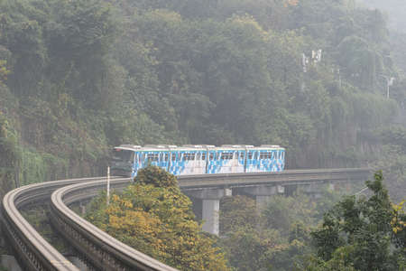 Chongqing, China - Dec 21, 2019: LIght railway passing accross mountainのeditorial素材