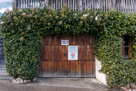 Interdiction of Drone sign and keep quiet sign on garage door in village Hallstattのeditorial素材