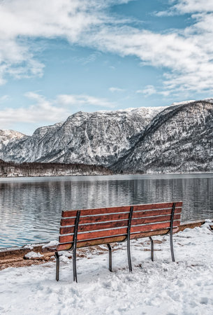 Benchs by lake with view of snow mountain during winter in Hallstatter, upper Austria