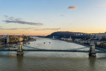 Aerial drone shot of chain bridge over Danube river during Budapest sunset winter timeの写真素材