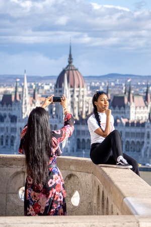 Budapest, Hungary - Feb 11, 2020: Instagram influencers pose for photo with Parliament in background in sunny winter morningのeditorial素材