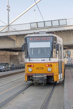 People board on Line 41 yellow tram trolley by Danube river in Budapestのeditorial素材