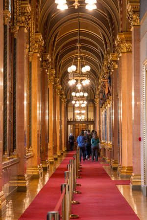 Budapest, Hungary - Feb 10, 2020: Tourists inside corridor with red carpet and gold ceiling in Parliament Buildingのeditorial素材