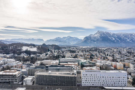 Aerial drone shot view of Salzburg Landeskrankenhaus with view of Untersberg snow mountainの写真素材
