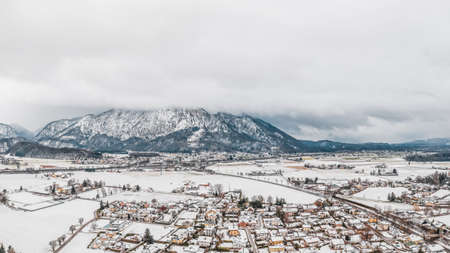 Aerial view of Austrian Alps valley village near Untersberg mountain and Salzburg outskirts in winter during heavy snowの写真素材