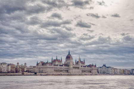 Hungarian Parliament facing Danube with clouds overhead in Budapest winter morningの写真素材