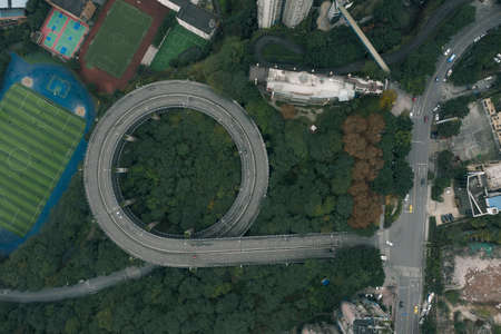 Aerial overhead shot of particular double circle 720 degree flyover in bushes residential buildings in Chongqing, Chinaの写真素材