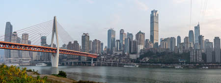 Qian si men suspension bridge over Jialing river, after sunset, view from river bank in Chongqing, southwest Chinaの写真素材