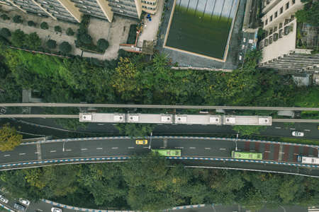Aerial drone overhead view of Chongqing light rail carriage to Liziba transit along residential buildings on the streetの写真素材
