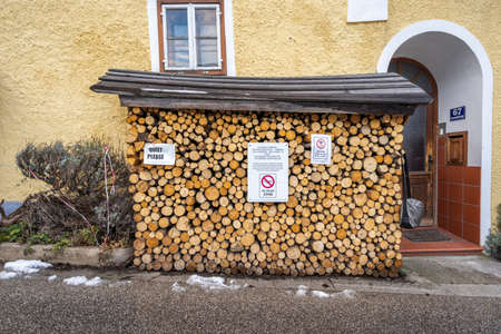 Feb 6, 2020 - Hallstatt, Austria: Woodpiles with post of keeping quiet and no drone zone in Hallstatt village in winterのeditorial素材
