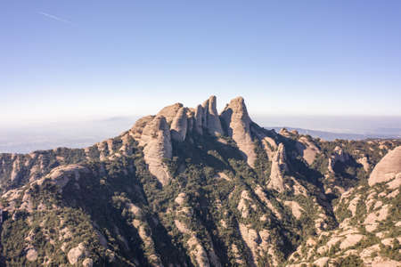 Aerial drone view of Holy Cave of Montserrat on mountain near Barcelona in sunrise in winterの写真素材