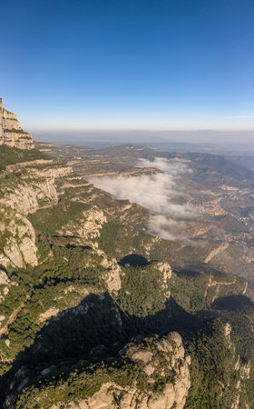 Aerial drone shot of Montserrat mountain cliff with fog in morning near Barcelonaの写真素材