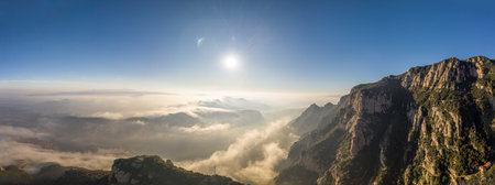 Panoramic aerial drone shot of morning clouds over Montserrat mountain near Barcelonaの写真素材