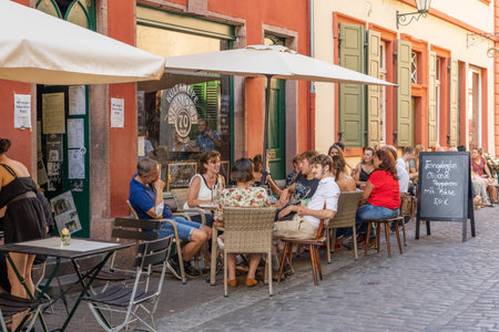 Heidelberg, Germany - Aug 1, 2020: Tourists having coffee in old town center in afternoon sunlightのeditorial素材