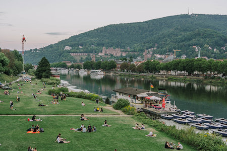 Heidelberg, Germany - Aug 1, 2020: People have picnics by Neckar river after sunsetのeditorial素材