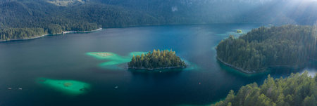 Panoramic aerial view of Eibsee lake island tree by Zugspitze before sunset in Germany