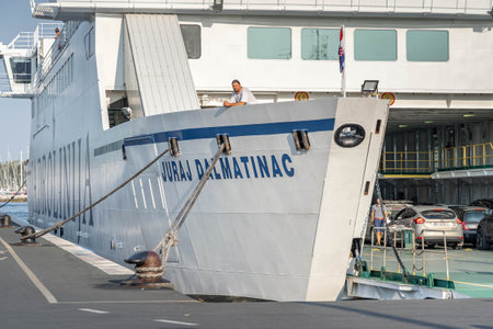 Split, Croatia - Aug 15, 2020: Tourists and cars board on jadrolinija liner ferry at old port in morningのeditorial素材