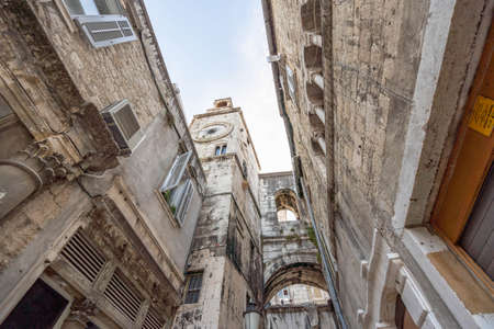 Split, Croatia - Aug 15 2020: Street view of ancient arch way clock tower at old townのeditorial素材