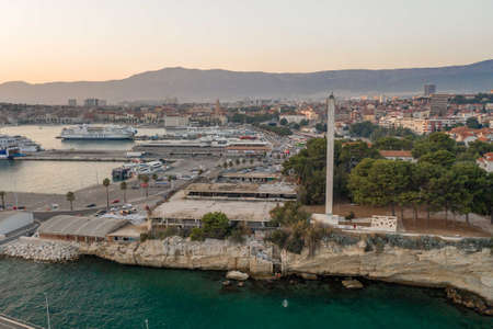 Split, Croatia - Aug 13, 2020: Aerial drone shot of port lighthouse by rock cliff in sunset hourのeditorial素材