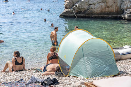 Vis, Croatia - Aug 17, 2020: Tourists sunbathing on sheltered cove Stiniva beach in summerのeditorial素材