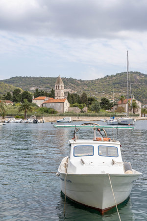 Vis, Croatia - Aug 18, 2020: Boat at old town port with view of St Jernima churh in backgroundのeditorial素材