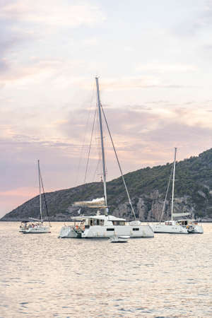 Komiza, Croatia - Aug 17, 2020: Boats and yachts catamarans on adriatic sea on vis island in sunsetのeditorial素材