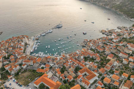 Aerial overhead done shot of Komiza town port on Vis Island in Croatia sunset hourの写真素材