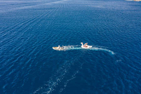 Vis, Croatia - Agu 18, 2020: Aerial drone shot tourists in inflatable speed boat in summerのeditorial素材